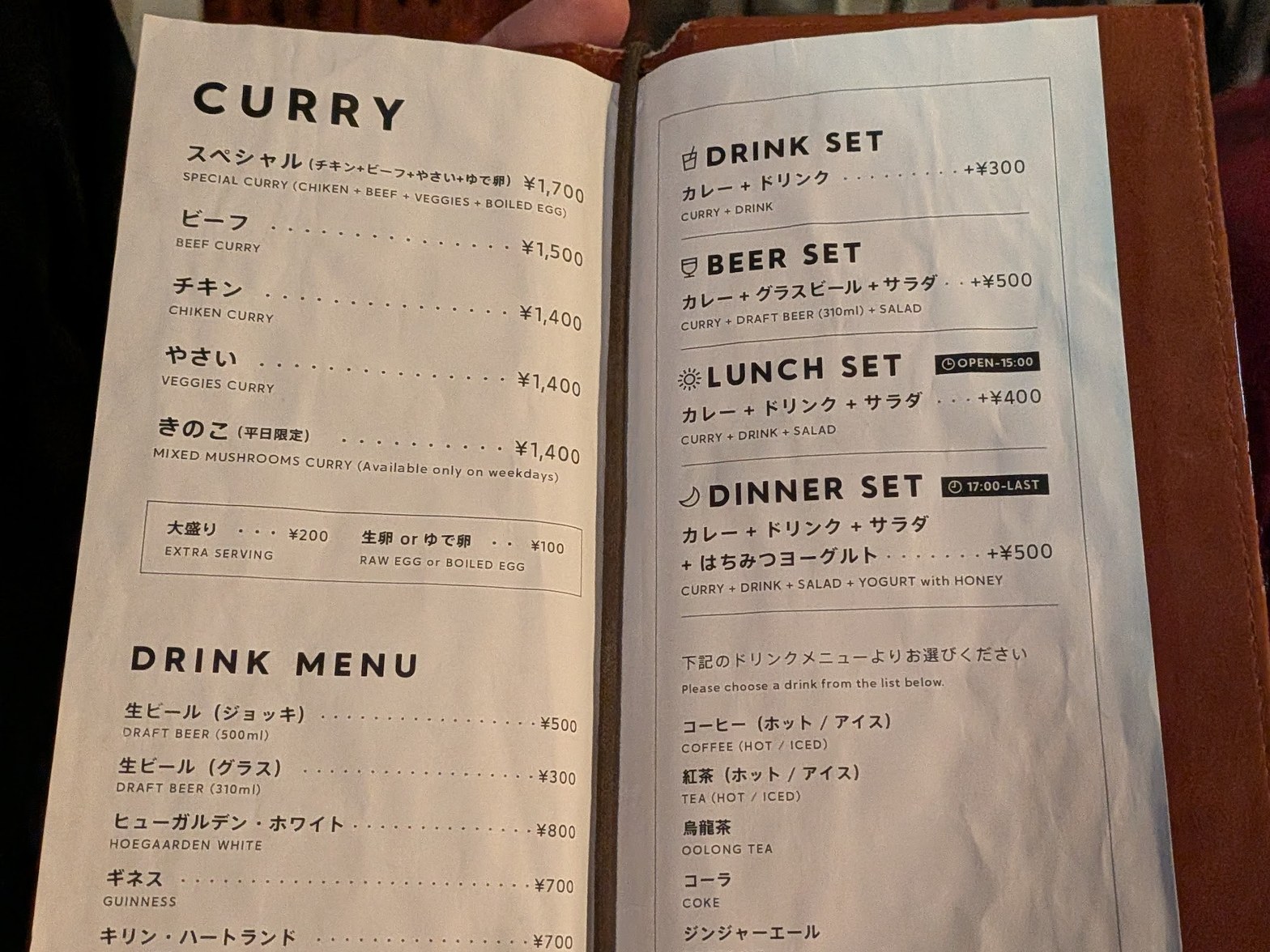 革張りのメニューブックを広げた見開き。左ページにCURRYとDRINK MENUの品名と価格、右ページにDRINK SET・BEER SET・LUNCH SET・DINNER SETの説明が印刷されている